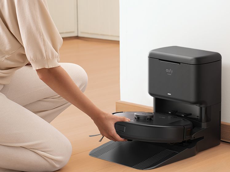 Utilisateur manipule son aspirateur robot domestique